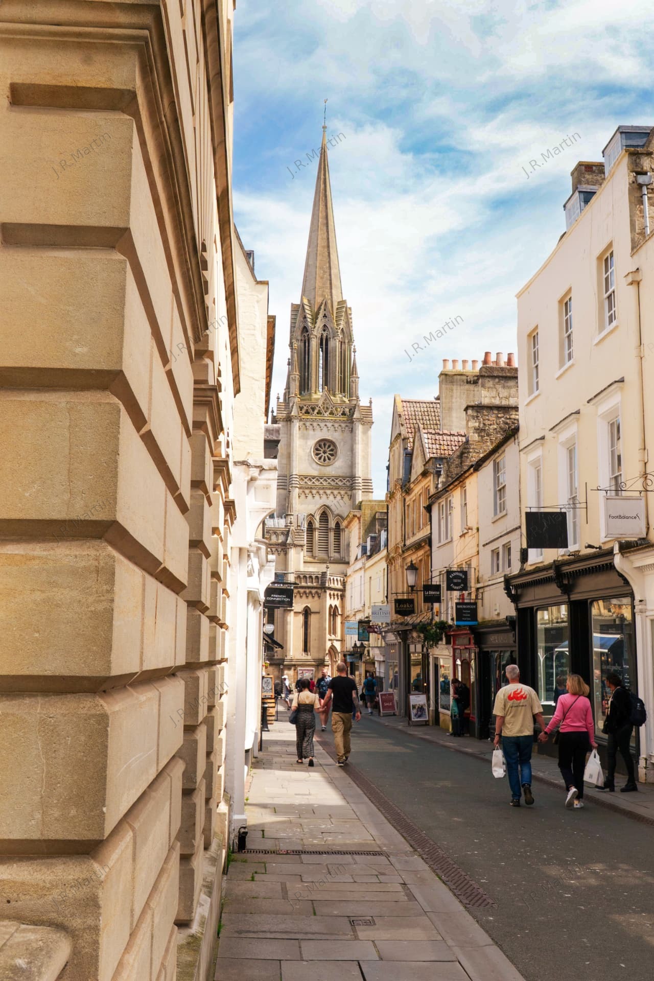 Narrow street leading to a church spire in Bath